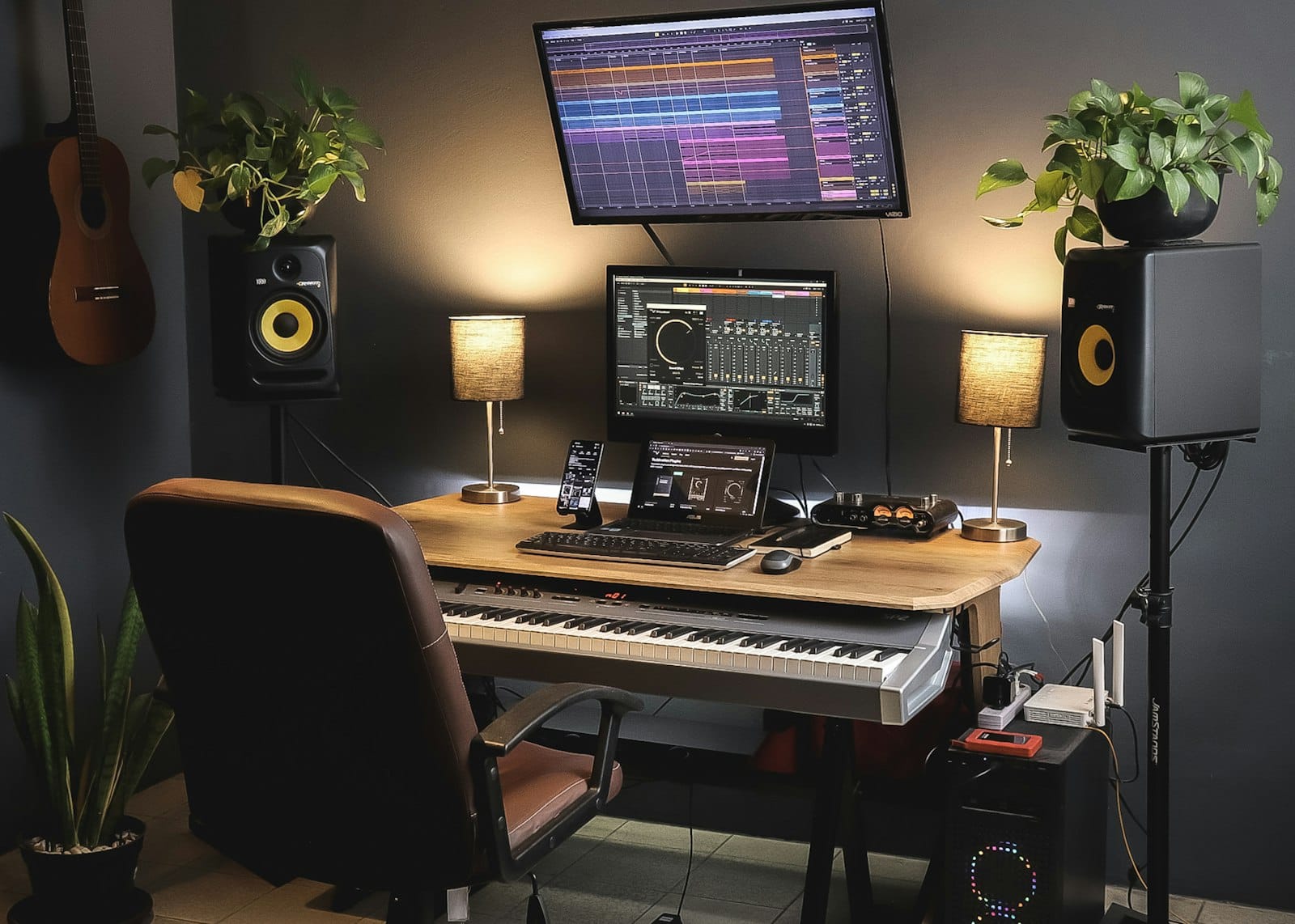 Stüdyo monitörleri, MIDI klavyesi ve iki ekranla kurulmuş bir home studio çalışma masası